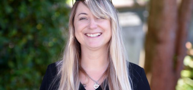Photograph of Kate Faust in front of trees