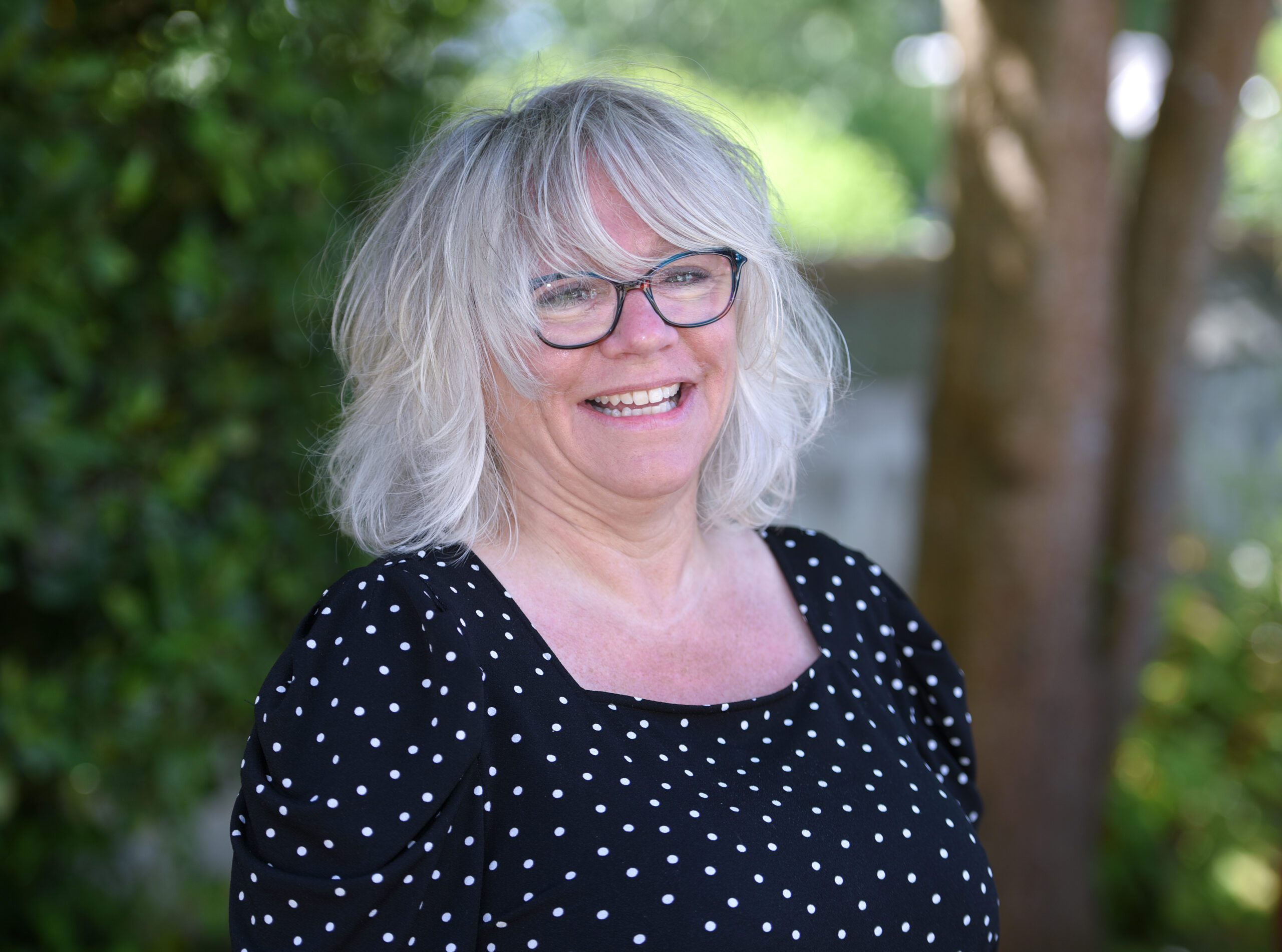 photograph of Manda Toms in front of trees